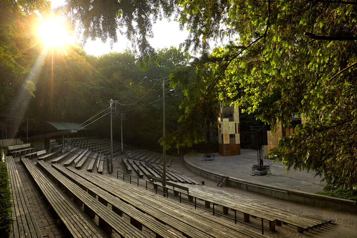 foto van een lege tribune en podium van Bostheater, met de zon die door de bomen heen schijnt