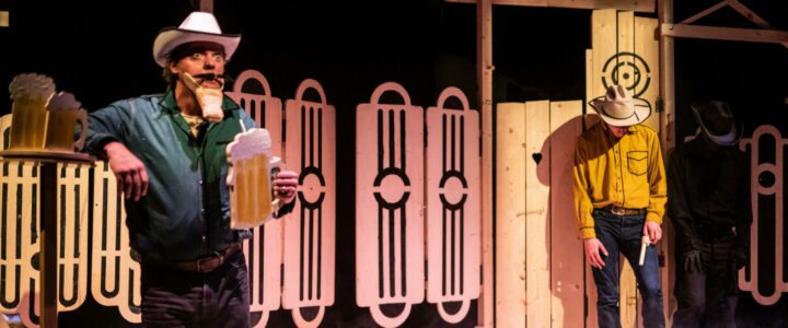 Scene foto van de kindervoorstelling Lucky Luuk. Lucky Luuk staat aan de rechterkant en een van de Dalton jongens staan aan de linkerkant en is geschrokken