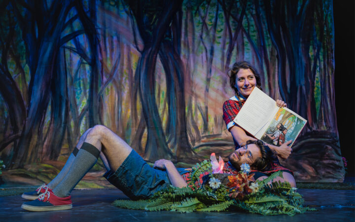 scenefoto van de kindervoorstelling Hans en Grietje. Met hans die op de schoot van grietje ligt